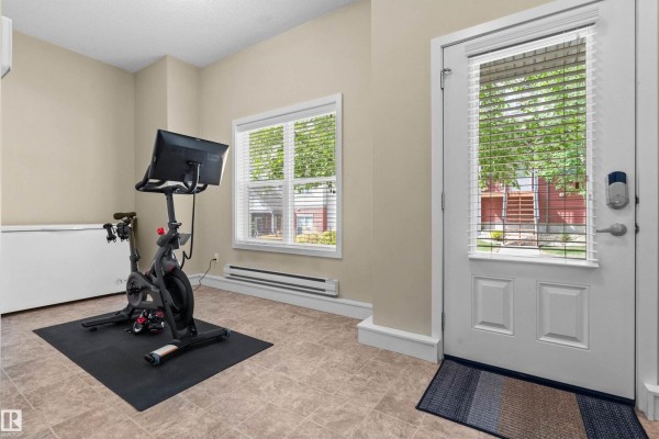Room with a stationary bike and a door opening to the outside. - #25 655 Watt Blvd Sw, Edmonton