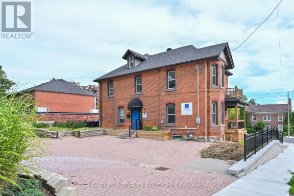 Reception area with blue door, wooden desk, and office equipment - 25 Berczy Street, Barrie