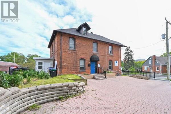 Waiting area with blue door, two chairs, and wooden desk - 25 Berczy Street, Barrie