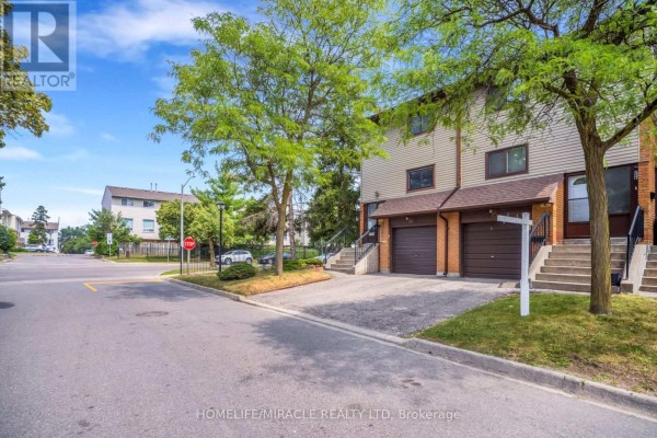 Street view of townhouse complex with surrounding residential buildings and trees. - 25 Carleton Place, Brampton