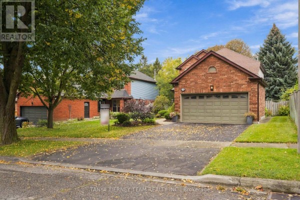 View of the property from the street showing the house, driveway, and neighboring houses. - 25 Coulton Court, Whitby
