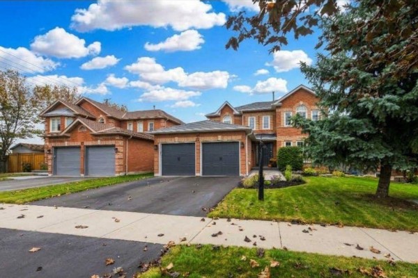Front exterior of a two-story brick house with a double garage on a sunny day. - 25 Dewbourne Place, Whitby
