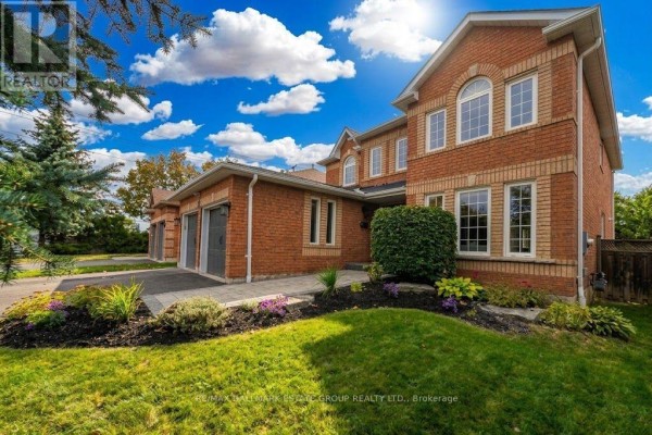 Side view of a large brick house showing multiple windows and manicured landscaping. - 25 Dewbourne Place, Whitby