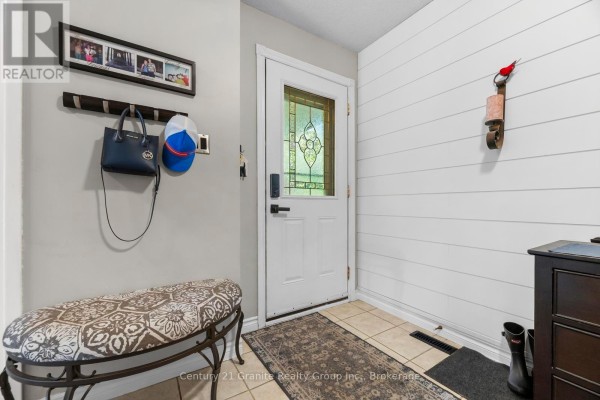 Interior entryway with a white door, bench, coat rack, and shiplap wall. - 25 Greenwood Road, Whitchurch Stouffville