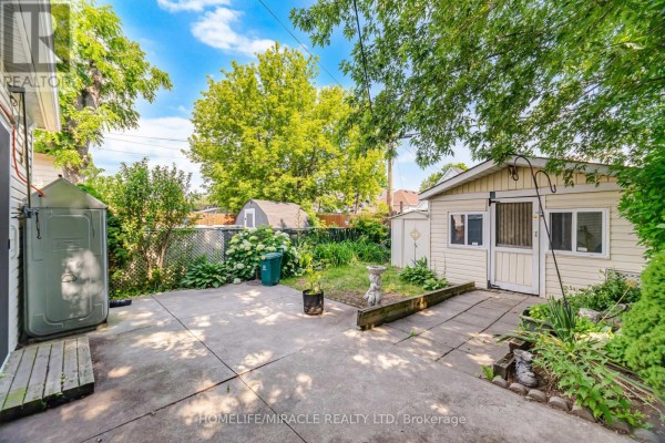 Concrete patio and storage shed in a backyard with landscaping - 25 Hope Avenue Hamilton