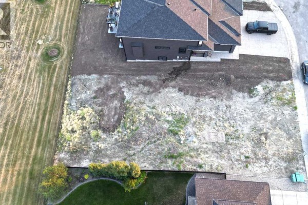 Overhead view of the vacant lot showing dirt and patchy grass, next to a house. - 25 Lakes Estates Circle, Strathmore