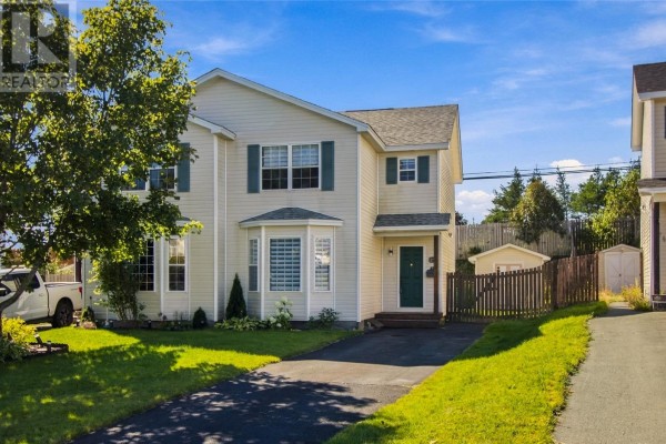 Cream-colored house with dark asphalt driveway, green shutters, and a wooden fence. - 25 Laumann Place, Mount Pearl