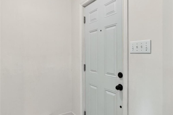 Interior view of a white panel door with black hardware and light switches. - 25 Laumann Place, Mount Pearl