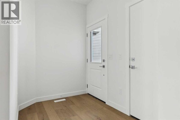 Interior entryway with light wood floors, white walls, and a staircase leading up. - 25 Linden Place, Rural Red Deer County