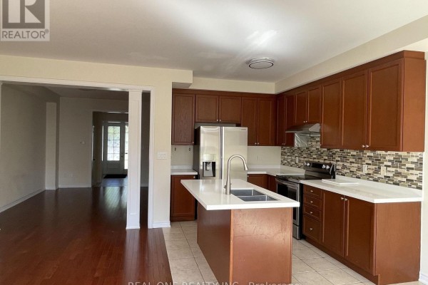 A kitchen with dark wood cabinets, white countertops, and stainless steel appliances. - 25 Paper Mills Crescent, Richmond Hill