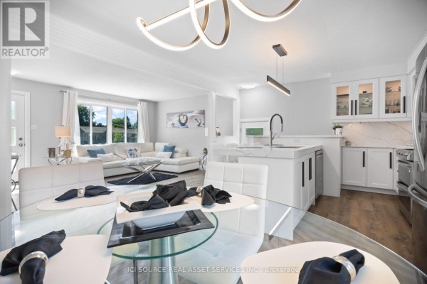 Open concept living, dining, and kitchen area with white furniture and island seating. - 25 Paulson Court, St  Thomas