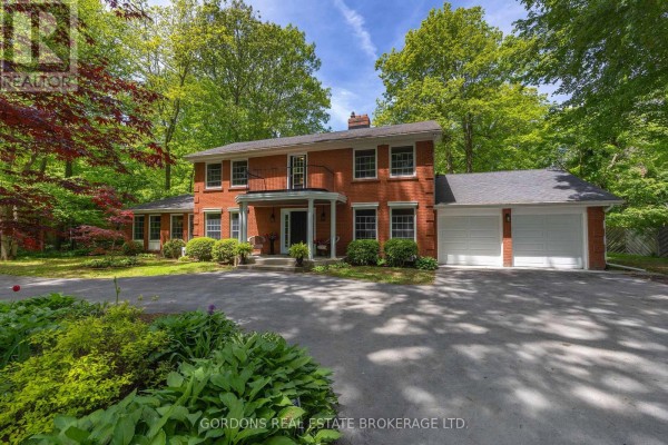 Front exterior of a two-story red brick house with a covered porch and attached two-car garage during the day. - 25 Riverside Drive, Kingston)