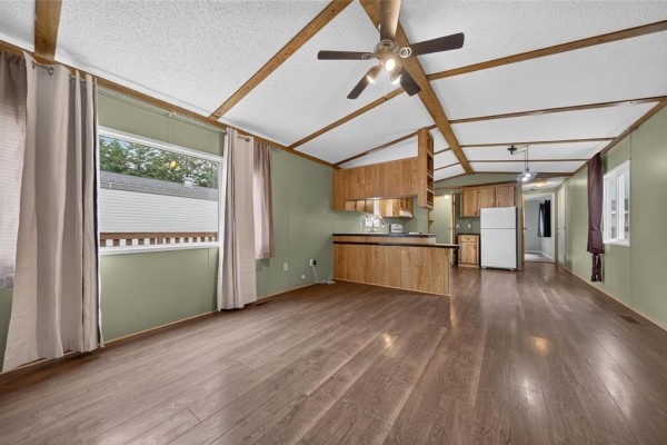 Interior room with light wood laminate flooring, beige walls, and a white door. - 25 Shay Crescent, Winnipeg