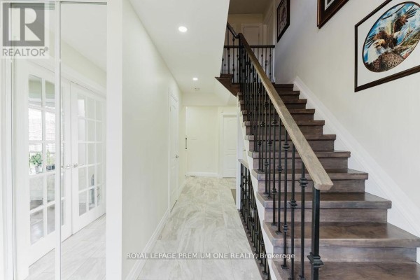 Front view of the home showcasing a double garage and snow-covered driveway. - 25 Sir Lancelot Court, Caledon