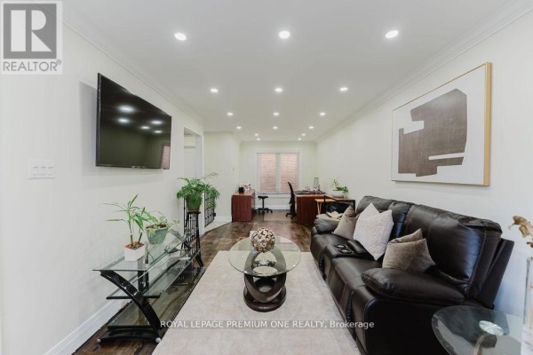 Living room featuring glass French doors, modern decor, and a flat-screen TV. - 25 Sir Lancelot Court, Caledon
