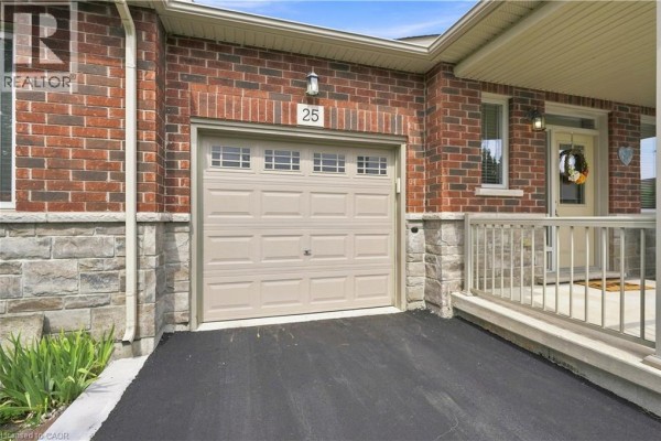 Close-up of the beige garage door and brick and stone exterior of a townhouse. - 25 Stickland Lane, Binbrook