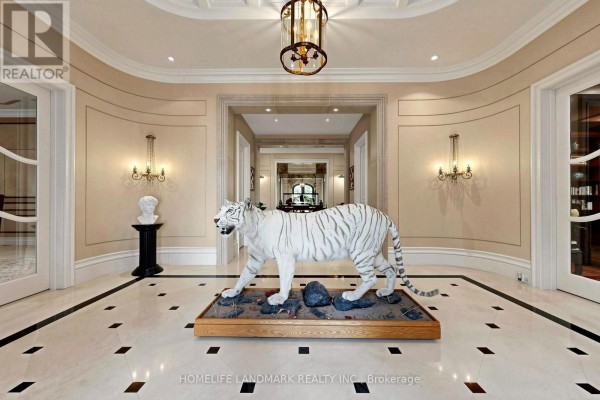 Luxurious foyer with marble floors, white tiger sculpture, pedestal bust, and ornate chandelier. - 25 The Bridle Path, Toronto