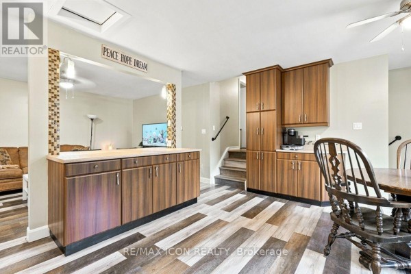 Kitchen with wood cabinets, tile backsplash, and laminate floors - 25 Upcott Crescent London South