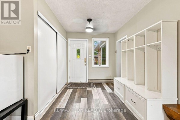 Hallway with built-in shelving and drawers, sliding door closet, and wood-look flooring - 25 Upcott Crescent London South