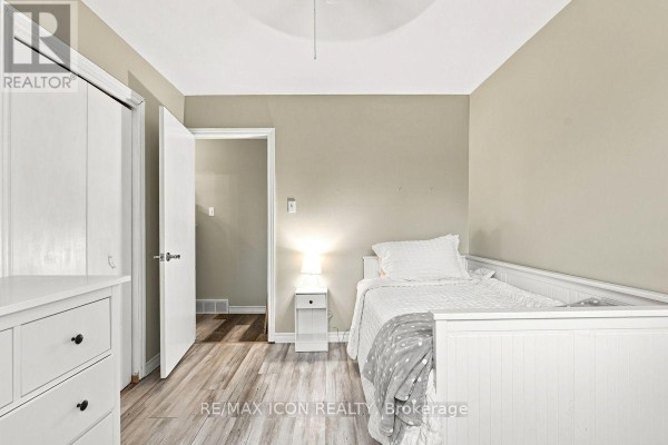 Bedroom with white bed, dresser, and wood floors - 25 Upcott Crescent London South
