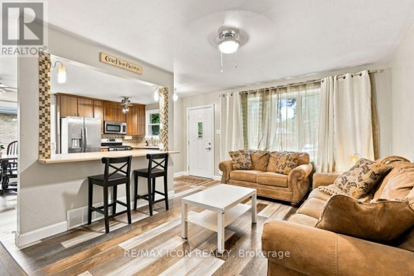 Living room with breakfast bar, sofas, and wood-look flooring - 25 Upcott Crescent London South