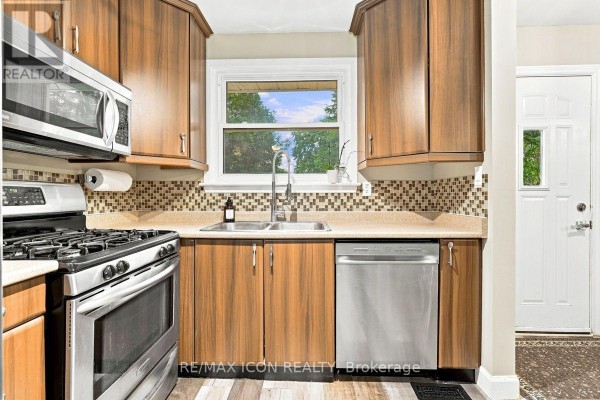Kitchen with wood cabinets, gas stove, stainless steel dishwasher, and double sink - 25 Upcott Crescent London South