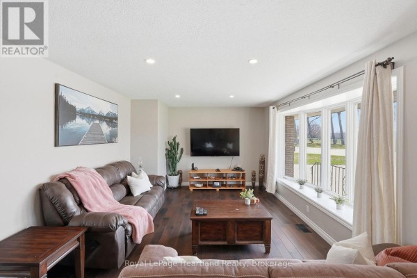 Leather sofa, bay window, and hardwood floors in living room - 25 Vincent Street South Bruce