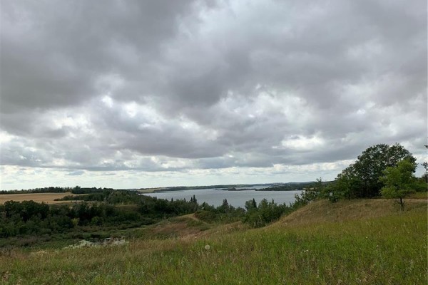 Overcast sky above rolling hills with trees and a distant body of water. - 25 Wakonda Drive, Hoodoo Rm No  401