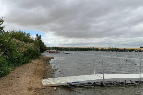 View of a sandy shoreline with a white dock and choppy water. - 25 Wakonda Drive, Hoodoo Rm No  401