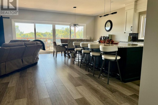 Living area with leather couch and view of the backyard through sliding glass doors. - 250 Colbeck Drive S, Welland