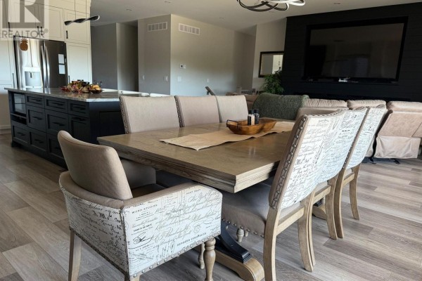 Dining table with upholstered chairs in a bright, open-concept living space. - 250 Colbeck Drive S, Welland