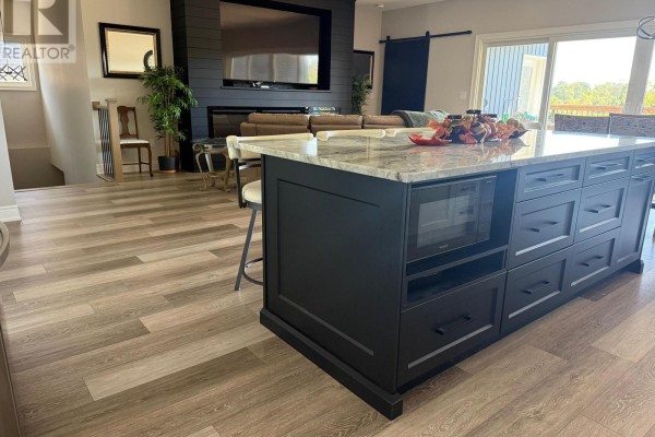 Kitchen island with granite countertop, microwave, and ample storage drawers. - 250 Colbeck Drive S, Welland