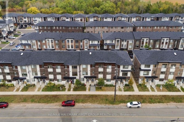 Aerial view of a townhouse complex with rows of connected homes and a street in front. - 250 Finch Avenue, Pickering