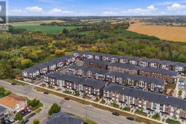 Aerial view showing multiple rows of modern townhouses with dark roofs and beige accents. - 250 Finch Avenue, Pickering
