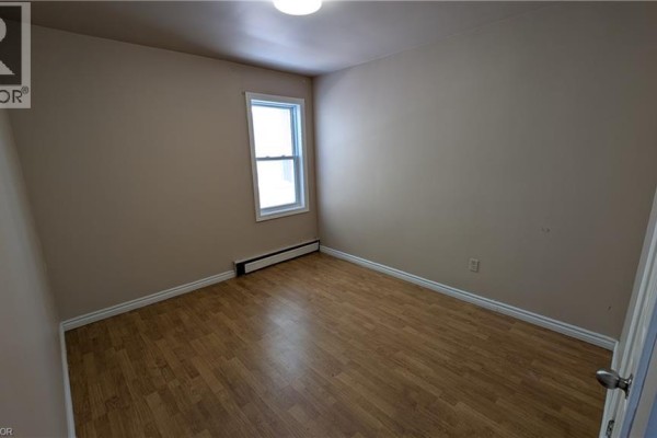 Bathroom with a bathtub, toilet, and sink, featuring grey tiled walls and a small window. - 250 Highland Road W Unit# 2 Main Right Side, Stoney Creek