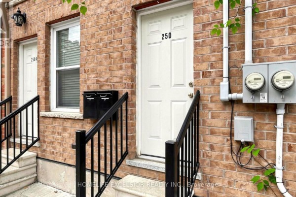 Close-up of a brick facade with a white door labeled 250, stairs, and electrical meters. - 250 Shuter Street, Toronto