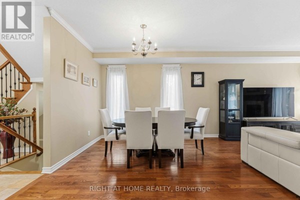 Formal dining room with large dark table, white chairs, and cabinetry. - 250 Tofino Private, Ottawa