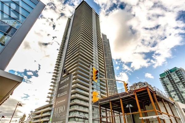 Street-level view of a tall condo building with balconies and commercial signage. - 2501 - 10 Park Lawn Road, Toronto