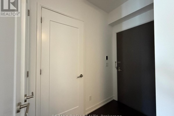 Apartment entryway with white door, dark door, and brushed nickel hardware. - 2501 - 88 Scott Street, Toronto