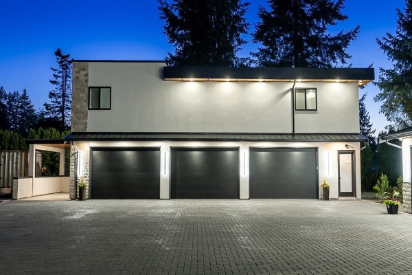 Interior foyer with double wooden front doors, geometric floor inlay, and a floating staircase. - 25031 57 Avenue, Langley