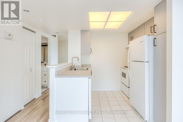 Bathroom with bathtub, shower curtain, white walls, and marble tiles. - 2504 - 5 Concorde Place, Toronto