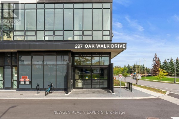 Close-up of the main entrance of 297 Oak Walk Drive with glass doors and a paved driveway. - 2505 - 297 Oak Walk Drive, Oakville