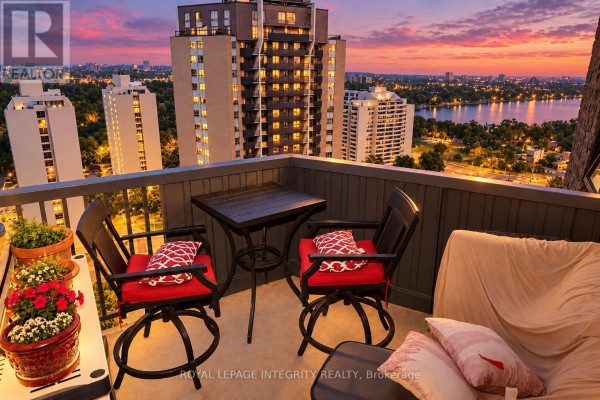 Living and dining area with a sofa, coffee table, dining set, and bar seating. - 2505 - 900 Dynes Road N, Ottawa