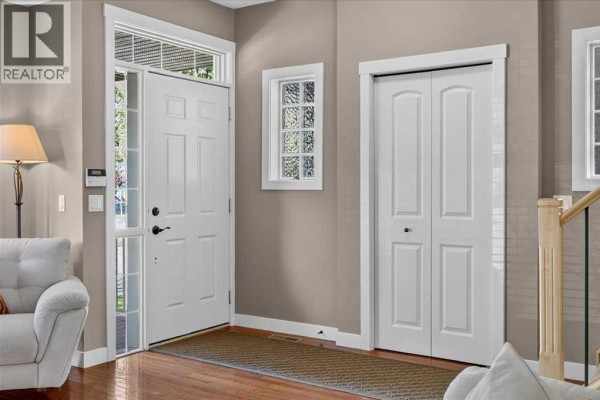 Interior entryway with a white front door, wood floor, and beige walls. - 2506 17 Street Se, Calgary