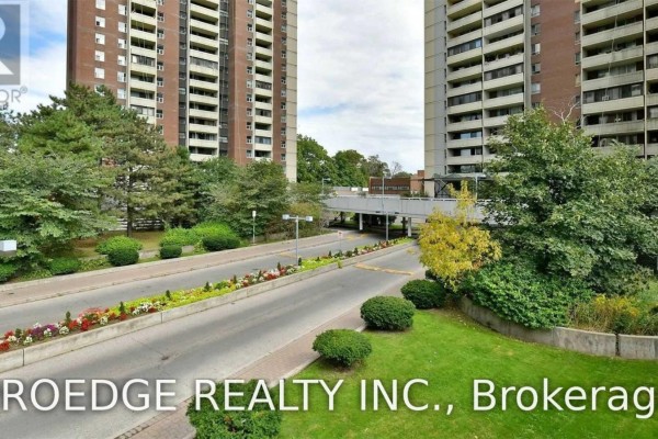 View of the entrance driveway and landscaped areas surrounding the apartment complex. - 2507 - 5 Massey Square, Toronto