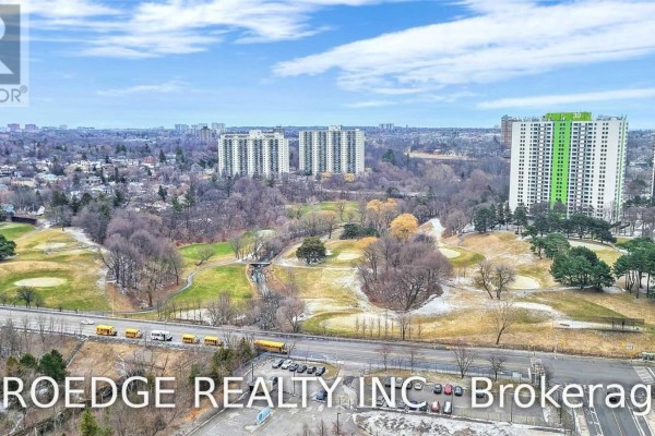 Aerial view of the apartment building with a golf course and city skyline in the distance. - 2507 - 5 Massey Square, Toronto
