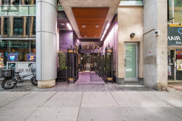 Lobby area with a fireplace, bookshelves, mirror, and seating. - 2509 - 375 King Street W, Toronto