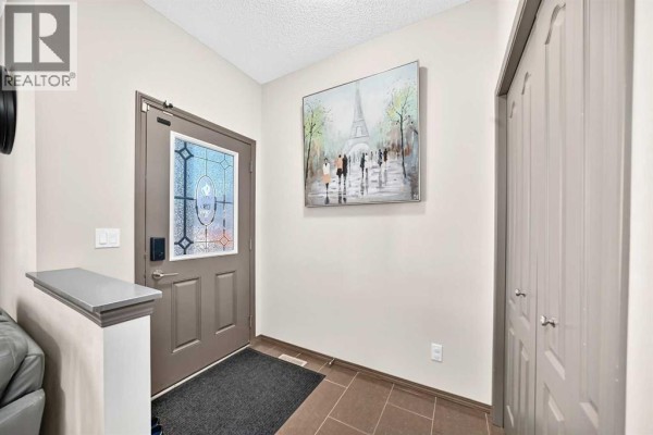 Interior entryway of the Calgary home with a grey door, tiled floor, and a large closet. - 251 Skyview Point Road Ne, Calgary