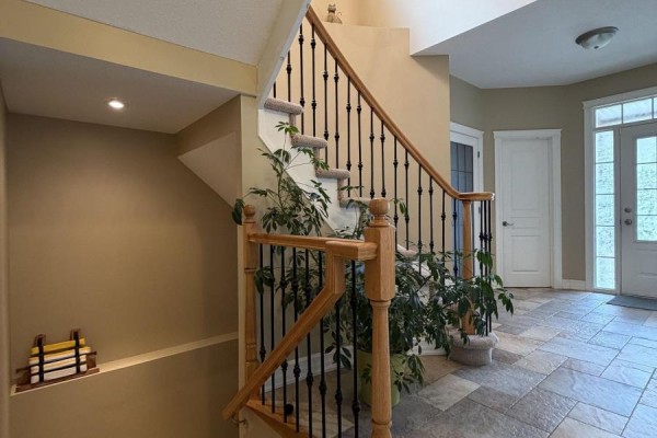 Interior staircase with carpeted steps, black spindles, and a wooden handrail. - 251 Tofino Private, Ottawa