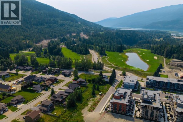 Aerial view of Revelstoke neighbourhood with townhouses, golf course, and lake in background. - 2513 Nels Nelson Crescent Lot# 6, Revelstoke